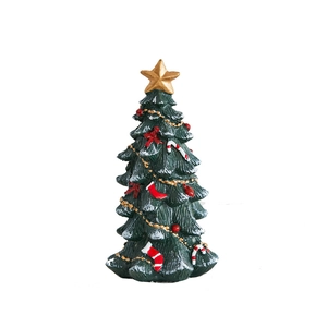 Miniature resin Christmas tree ornament with festive bows and star on white background