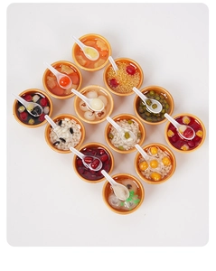 Overhead view of twelve miniature golden dessert bowls with various Asian food styles