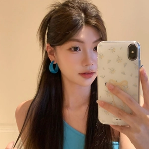 Blue acrylic geometric C-shaped hoop earrings worn by model in a stylish mirror selfie