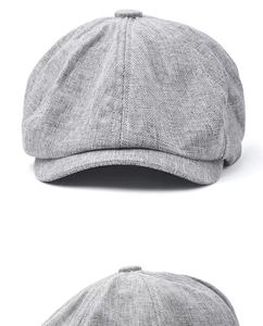 Detailed macro view of light gray linen texture and stitching on a newsboy cap