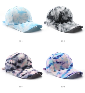 Detail view of four tie-dye cotton baseball caps in various color patterns and styles