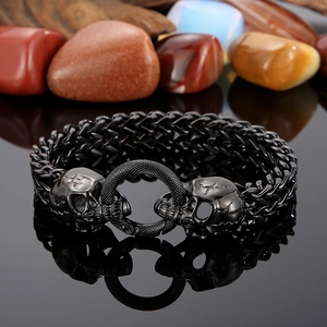 Detailed close-up of double skull buckles on a polished black stainless steel punk bracelet