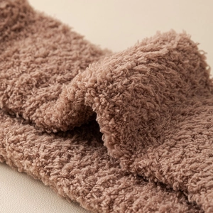 Close-up macro view of soft fuzzy brown coral fleece texture for winter thermal toe socks