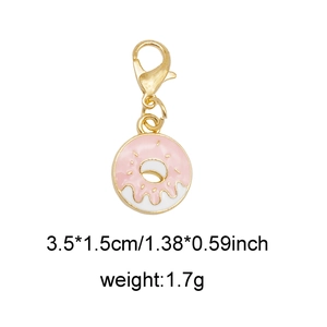 Macro view of a gold doughnut charm with pink frosting, lobster clasp, and dimensions