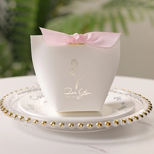 Elegant white wedding favor box with pink ribbon bow and gold tulip print for guests