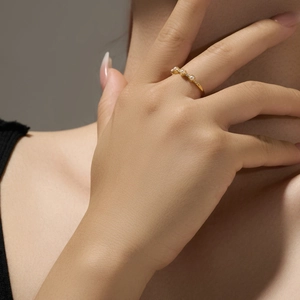Detail view of s925 silver gold-plated ring with elegant mini pearls on model finger