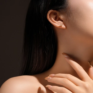 Close-up of golden bird stud earring with sparkling zircons on a model's ear
