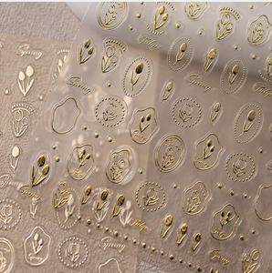 Detail of 3D embossed gold tulip nail stickers with Spring artistic lettering