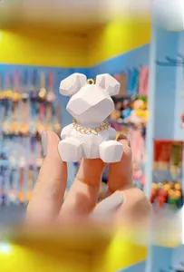 Detailed macro view of a white resin rabbit keychain with geometric facets and golden chain