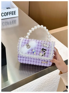 Detail of girls' purple houndstooth handbag with pearl handle, lace trim, and bear charm