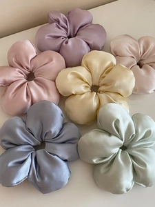 Close-up of assorted macaron colored satin flower hair scrunchies with silky texture