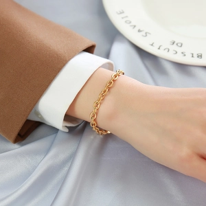 Dettaglio di un bracciale a catena con maglie ovali placcato in oro 18k al polso