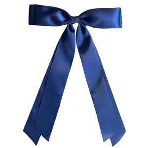Detailed view of the smooth glossy dark blue satin ribbon bow hair clip texture