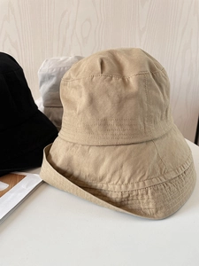 Detail of cotton canvas sun hats showing parallel stitching and minimalist khaki colors
