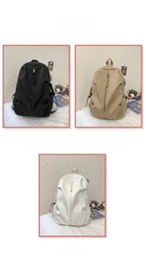 Detail view of large backpacks in black, khaki, and white with vertical front zippers
