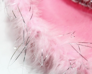 Close-up of pink cowboy hat featuring fluffy feather trim with silver shimmering tinsel