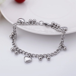 Detail of silver stainless steel chain bracelet with polished heart and ball pendants