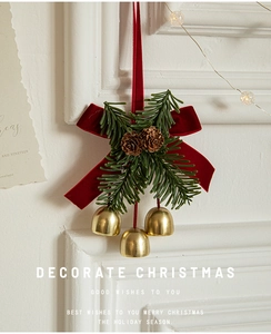 Detail of Christmas bow with pine cones, needles and golden bells for tree decoration