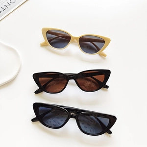 Three pairs of vintage cat eye resin sunglasses in beige and black on white background