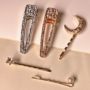 Close-up of a 5-piece gold and silver hair clip set with crescent moon and star rhinestones