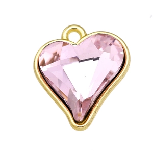 Macro shot of pink heart-shaped crystal pendant with gold rim for DIY jewelry