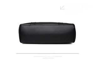 Detailed bottom view of black faux leather tote bag showing neat stitching and lychee texture