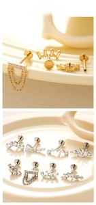 Flat back titanium cartilage studs with cubic zirconia and chain charms on display