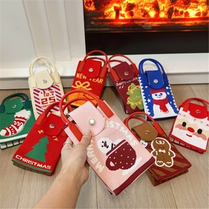Mini Christmas knitted phone bags with festive patterns on cozy wooden background