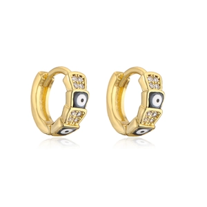 Macro shot of gold hoop earrings featuring enamel evil eye charms and sparkling zircons