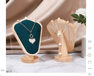 Detail of dark green velvet necklace display stand with premium solid wood base for jewelry