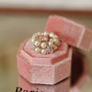 Detailed macro view of double-row pearl ring with zircon stars in a pink velvet box