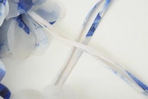 Détail de l'ourlet de robe en dégradé bleu et blanc avec de fines bretelles délicates
