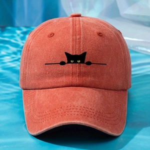 Close-up of embroidered black cat on a vintage washed brick red cotton baseball cap