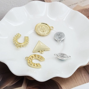 Macro shot of assorted gold and silver geometric eye pendants for DIY jewelry making