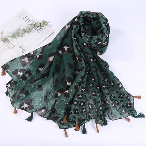 Detailed view of lightweight green leopard print scarf with delicate fringe tassels
