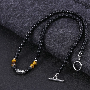 Detail of beaded necklace featuring black agate and tiger eye stones with metal clasp