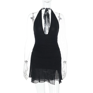 Detailed view of black halter mini dress featuring ruched fabric and sheer mesh hemline