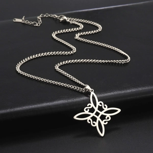 Polished stainless steel Celtic knot pendant necklace on silver Cuban chain and black surface