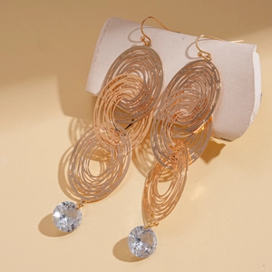 Detail of gold multilayer hollow geometric earrings with clear round crystal stone