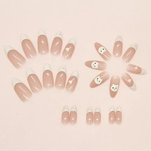 Detail view of almond press-on nails featuring yellow French tips and cute bear art