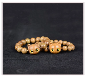 Détail de deux bracelets en bois faits main avec perles brunes et pendentifs chat
