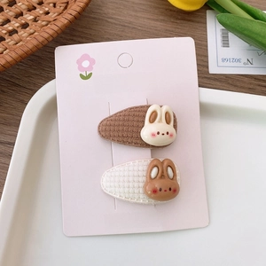 Detailed view of plush rabbit hair clips with fabric-wrapped clips on a display card