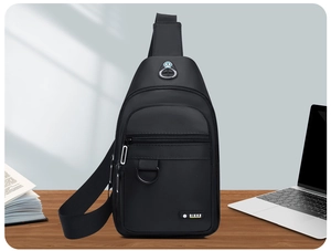 Close-up of black water-resistant oxford fabric chest bag with zipper pockets and headphone port