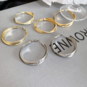 Trois paires de créoles entrelacées en or 18 carats et argent avec une texture mate