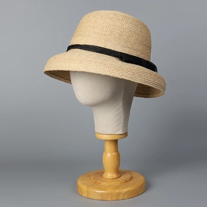 French style raffia straw hat with black ribbon on a mannequin head for sun protection