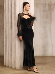 Elegant black velvet evening dress with sheer mesh sleeves and feather trim details