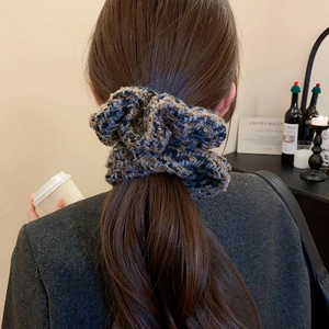 Détail d'un chouchou en maille à carreaux avec paillettes porté dans un café chaleureux