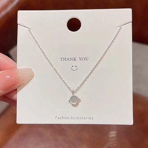 Dettaglio di un ciondolo a cuore in argento con gemma su cartoncino da esposizione