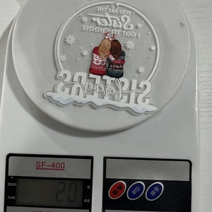 Detailed view of an acrylic Christmas ornament on a digital scale showing its weight