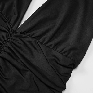 Détail du décolleté en V profond et taille froncée sur la robe moulante noire